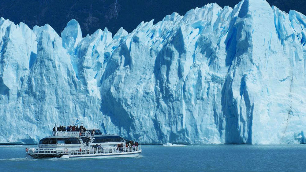 Barcos que fazem a travessia do lago ao lado dos paredões de gelo